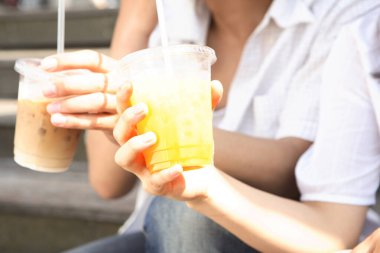 Arkadaşlar açık havada serinletici buzlu içecekler içiyorlar.