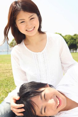 Güneşli bir havada dinlenen gülümseyen çift.