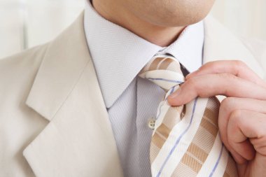 Takım elbiseli adam kravat ayarlıyor. İş adamına yaklaş..