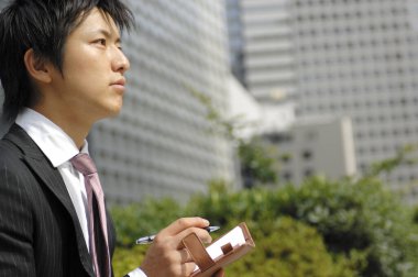 Şehirde not defteri olan genç bir işadamı.