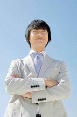 Gökyüzü geçmişi olan Asyalı iş adamının portresi 