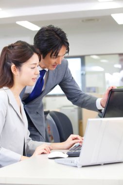 Bir adam ve bir kadın bir bilgisayara bakıyor.