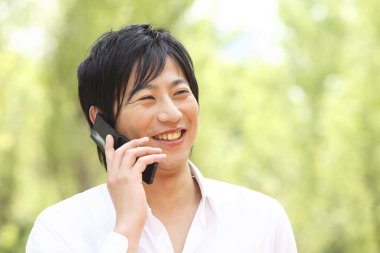 Arka planda cep telefonu olan Asyalı bir adamın portresi