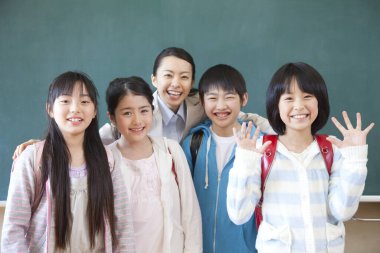 Bir grup mutlu Asyalı öğrenci sınıfta. 