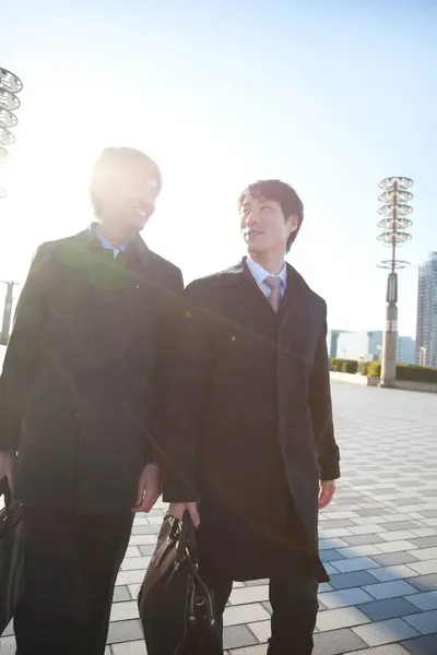 two men in suits walking on street
