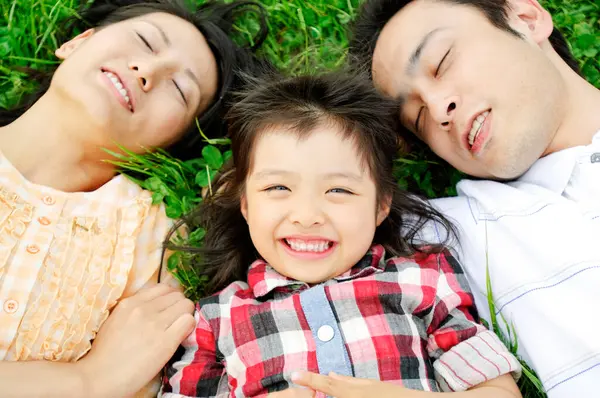 Ευτυχισμένη Νεαρή Ασιατική Οικογένεια Στο Γρασίδι Στο Πάρκο — Φωτογραφία Αρχείου
