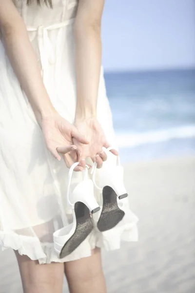Une Femme Tenant Une Paire Chaussures Sur Plage — Photo