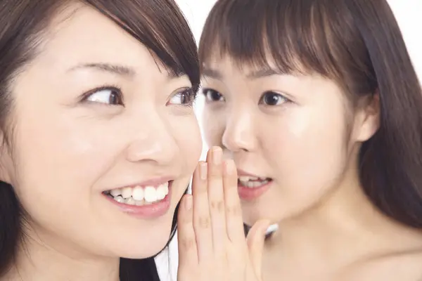 Two Asian Women Smiling Telling Secret Stock Photo
