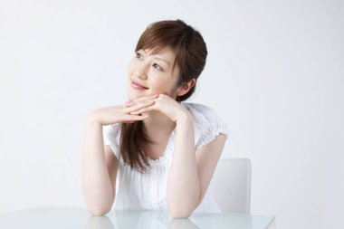 Masada oturan beyaz elbiseli Asyalı kadın. 