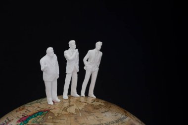 Küresel iş dünyası kavramının üzerinde duran minyatür iş adamları          