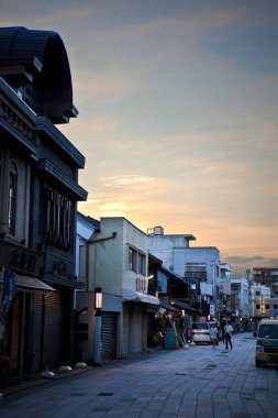 Gün batımında ya da şafakta şehir caddesinde yol boyunca binalar