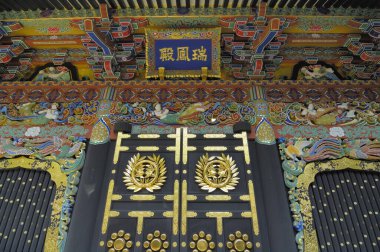 Karmaşık oymalar ve altın aksanlı Japon tapınağının kapısını süsleyin.