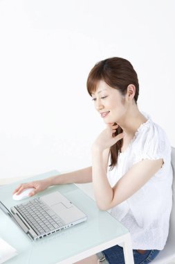 Evde dizüstü bilgisayarla çalışan Asyalı kadın. 