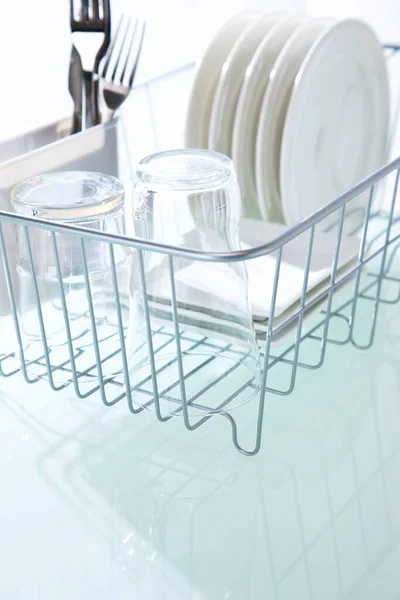 clean dishes in dishwasher rack on clean kitchen table