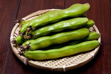 Tahta arka planda bambu sepetinde taze yeşil fasulye.