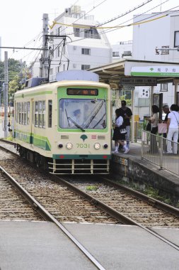 Gündüz vakti tramvaydaki insanlar Japon şehrinde