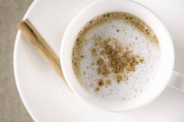 Seramik fincanda tarçınlı sıcak kahve kapuçinosu.