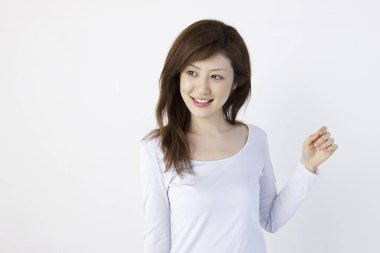 Genç Asyalı kadın beyaz arka planda yalnız poz veriyor. 