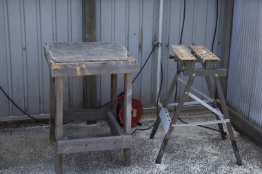 Metal testerenin yanında duran eskimiş ahşap tezgah.