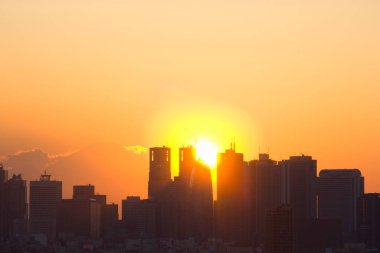 Şehrin üzerinde gün batımı. Gün batımında gökdelenlerin siluetleri