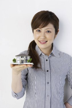 Genç bir kadın model evi tutuyor.