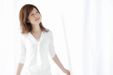 Beyaz gömlekli genç kadın gülümsüyor.