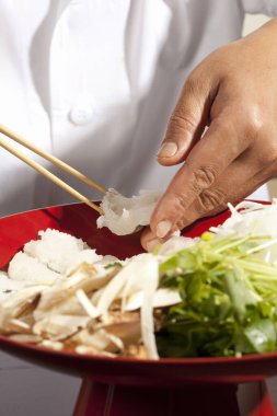 Yakın plan. Beyaz arka planda suşi yapan kadın elleri..