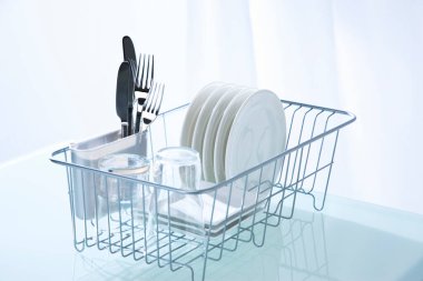 Temiz mutfak masasındaki bulaşık makinesinde temiz tabaklar.