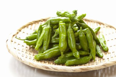 Bambu sepetindeki taze organik yeşil biber manzarasını kapat.