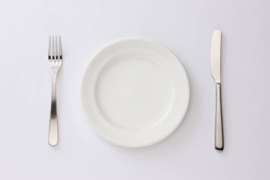 Çatal, bıçak ve plaka beyaz arka planda