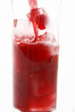 Beyaz zemin üzerinde buz küpleri olan kırmızı kokteylin yakın görüntüsü