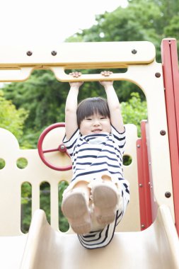 Asyalı küçük kızın portresi oyun alanında eğleniyor.