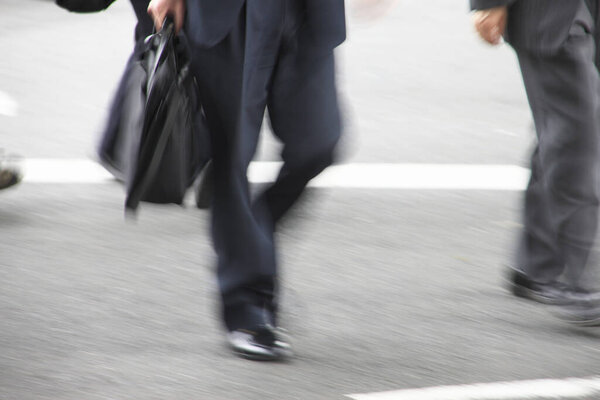 low section view of businessman walking on street. Motion blur