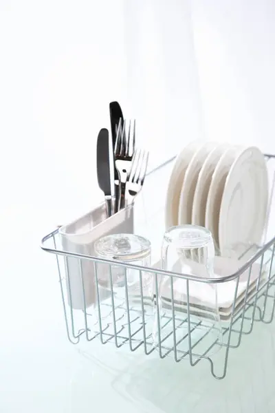 洗碗机架上干净的碗碟放在厨房干净的桌子上 — 图库照片