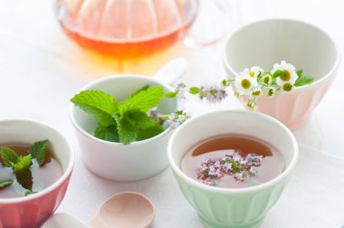 Masada çiçekler olan bir fincan bitki çayı.