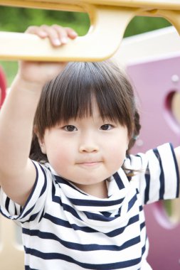 Asyalı küçük kızın portresi oyun alanında eğleniyor.