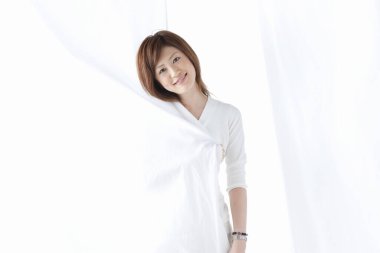 Beyaz arka planda poz veren genç Asyalı kadın 