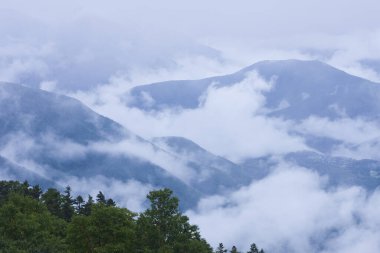 Manzaralı dağların üzerindeki bulutlarla güzel bir manzara.       