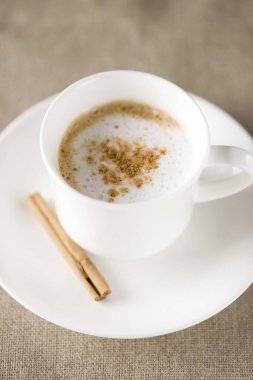 Seramik fincanda tarçınlı sıcak kahve kapuçinosu.