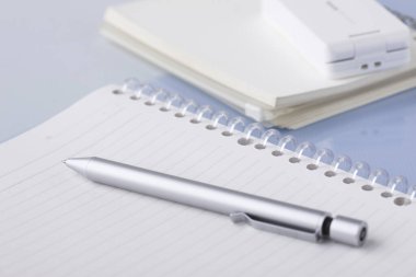 Beyaz arkaplanda boş defter ve kalemi kapat