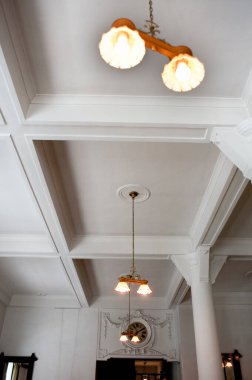 Modern otelin içi, avizeli beyaz tavan.