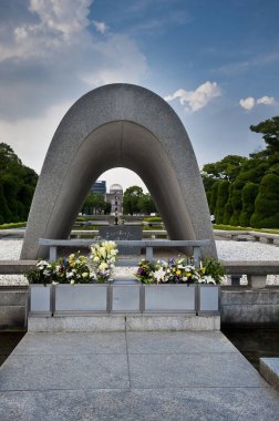 Hiroşima Barış Anıt Parkı 'ndaki Atom Bombası Mağdurları Cenotaph' ı, Hiroşima, Japonya 'da onarılmamış bir hatıra olarak bırakılmış belediye binası manzarası..