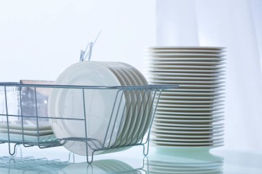 Temiz mutfak masasındaki bulaşık makinesinde temiz tabaklar.