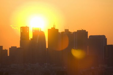 Şehrin üzerinde gün batımı. Gün batımında gökdelenlerin siluetleri