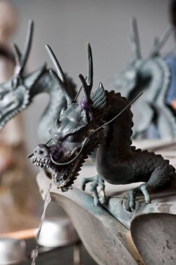 Efsanevi Asyalı ejderha heykeli güneşin altındaki bir Japon parkında görkemli bir şekilde duruyor.