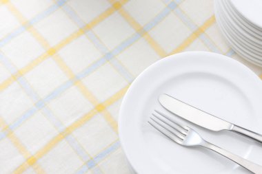 Beyaz tabak çatal ve bıçak masada, üstten görünüm