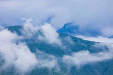 Manzaralı dağların üzerindeki bulutlarla güzel bir manzara.       