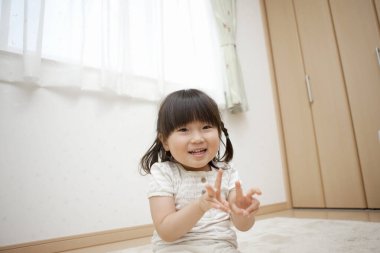 Küçük mutlu Asyalı kız parmağıyla oynuyor. 