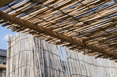 Doğal ahşap yapı açık mavi gökyüzünün altında gölge oluşturuyor.