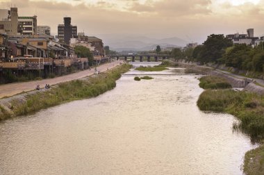 Japon şehir sokağının ve nehrin gün batımındaki güzel manzarası.